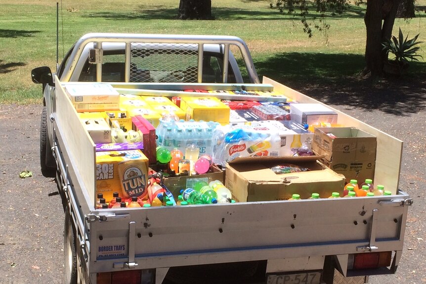 Lots of drinks, beer and soft drink cartons, in the back of a ute