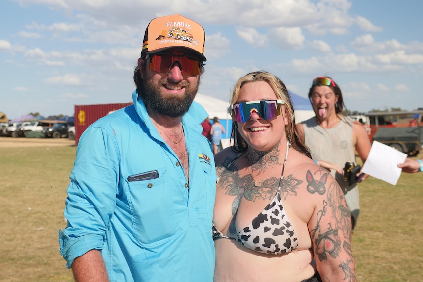 a photo of a couple, including woman in bikini with tattoos 