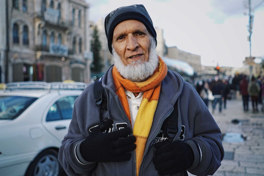 Abbu from East Jerusalem stands in a crowded street.