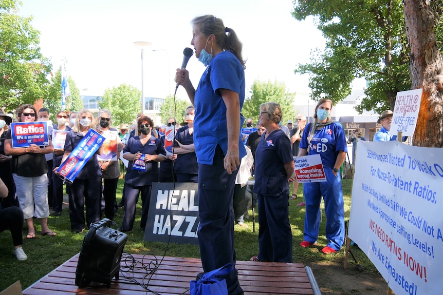 A woman addresses a crowd of nurses