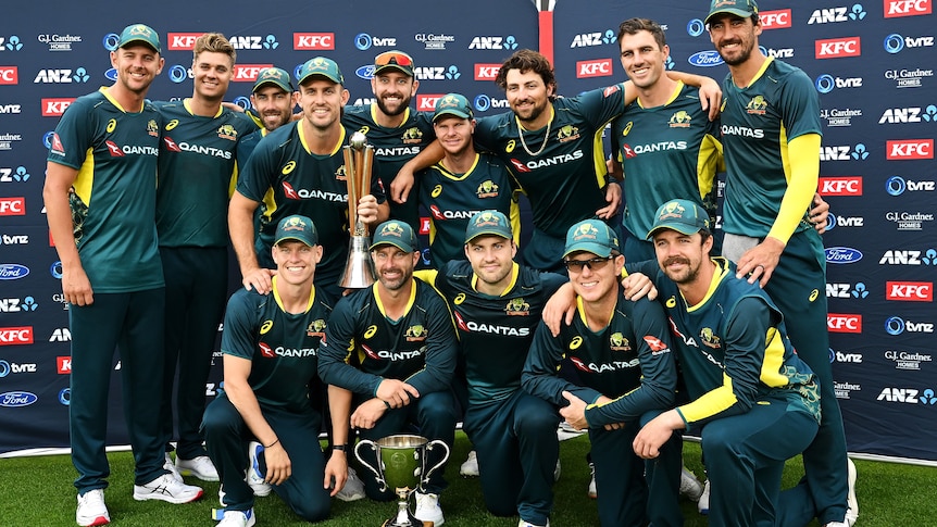 Australia's T20 team huddles around the Chappell-Hadlee Trophy