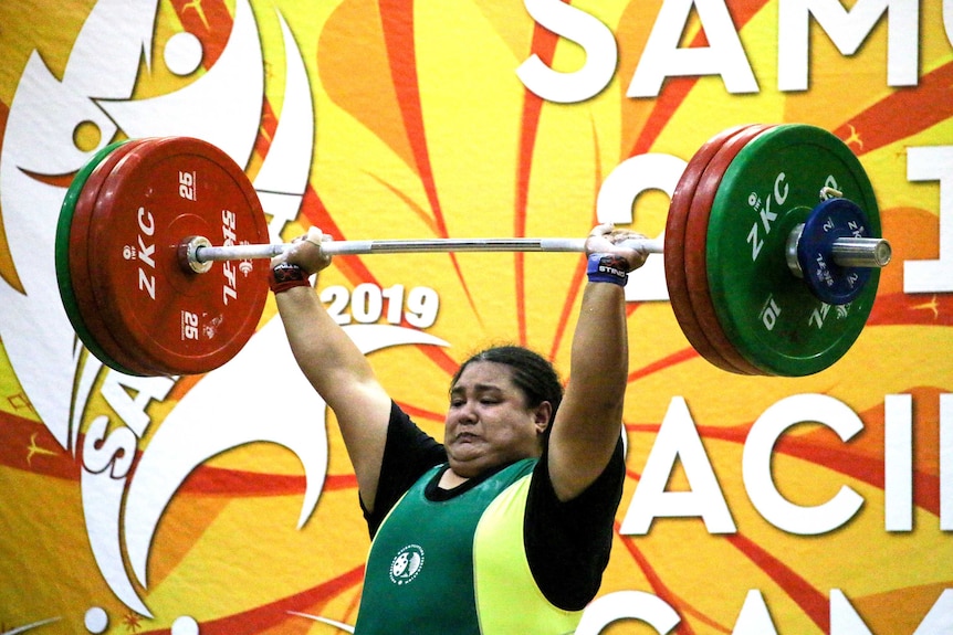 Charisma Amoe-Tarrant concentrates as she lifts a more than 120kg barbell above her head at the 2019 Pacific Games in Apia.