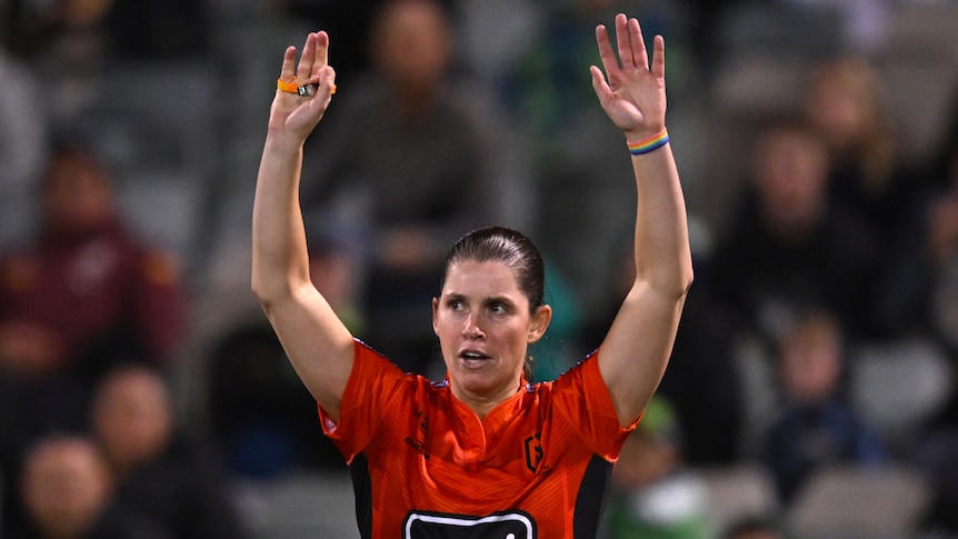 NRL referee Kasey Badger holds her hands up during a game between the Gold Coast Titans and Canberra Raiders.