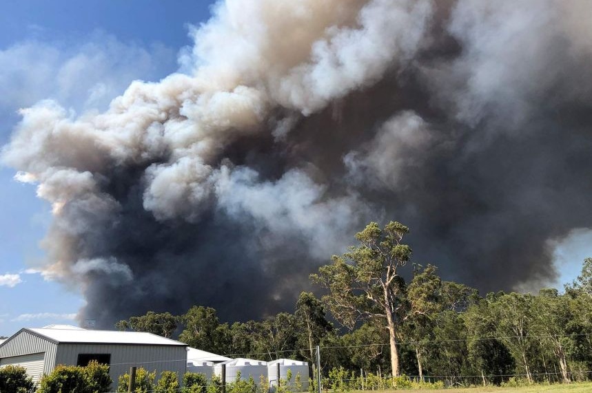 A shed in the foreground and smoke in the background.