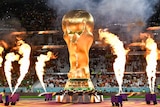 Flame throwers go off around an inflatable replica of the FIFA World Cup trophy in Qatar.
