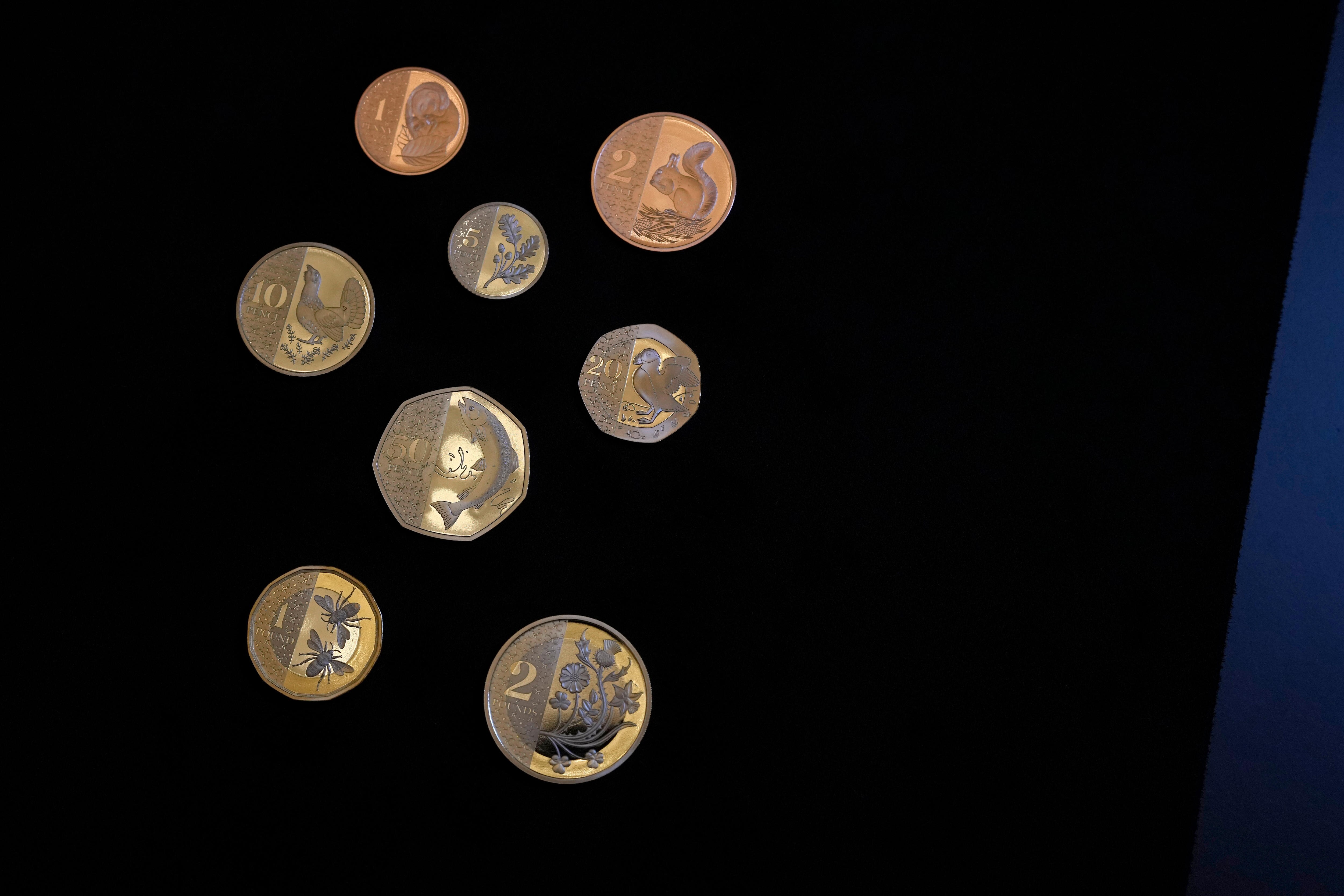 Seven British coins on a black background. 