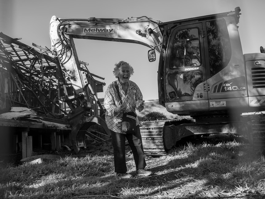 Louise Goode shouts as her former house is demolished behind her.