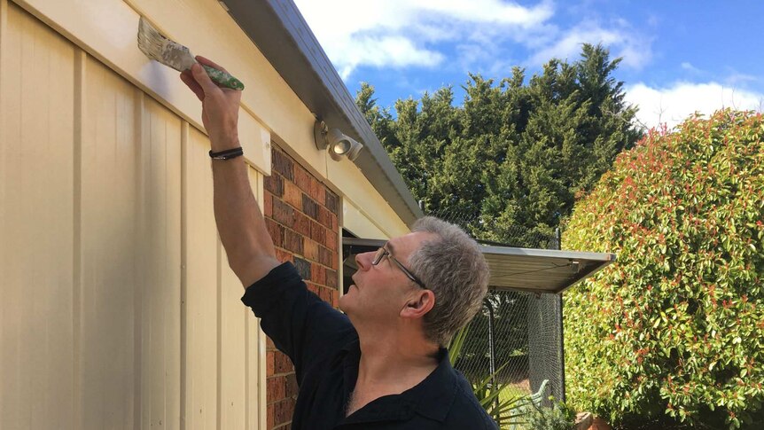 David Halliwell painting a house.