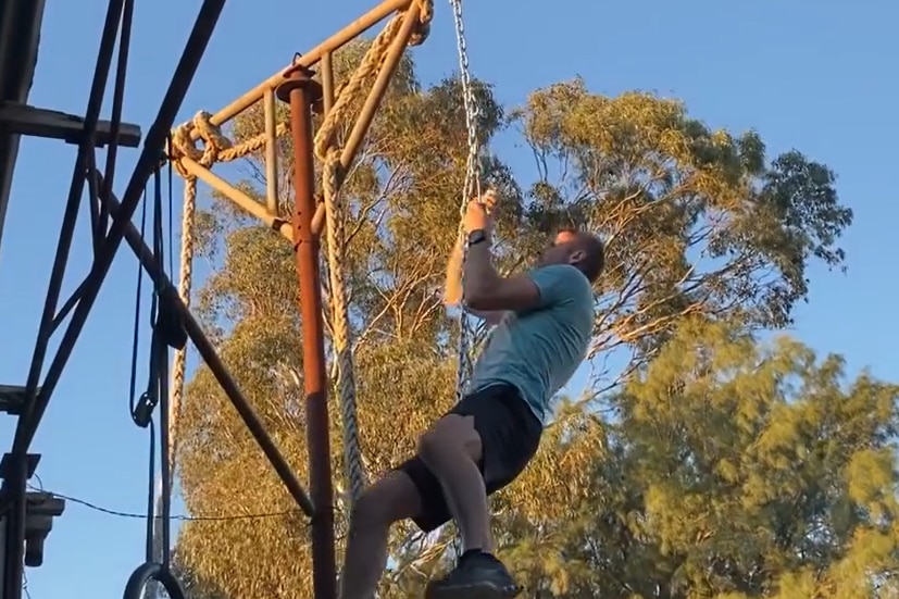 A man climbs a chain.