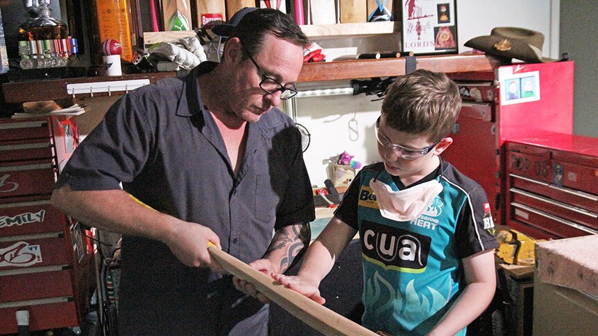 Operation Straight Drive Riley and Matt Parsons inspect a refurbished cricket bat