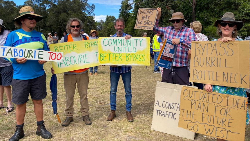 A group of burrill lake residents with bypass route protest signs.