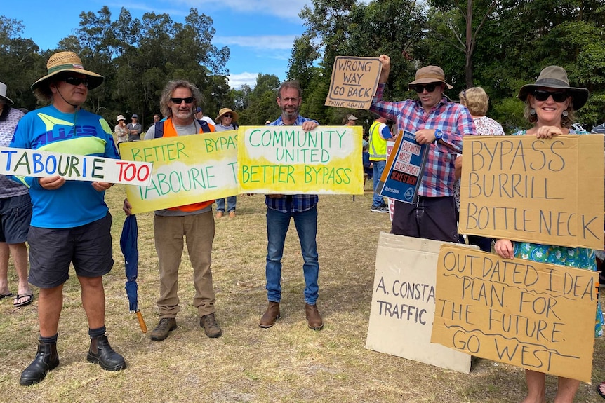 A group of burrill lake residents with bypass route protest signs.