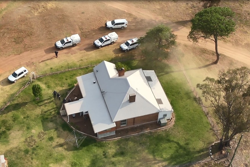 Aerial shot of a rural property in Menah with police vehicles circling on the road
