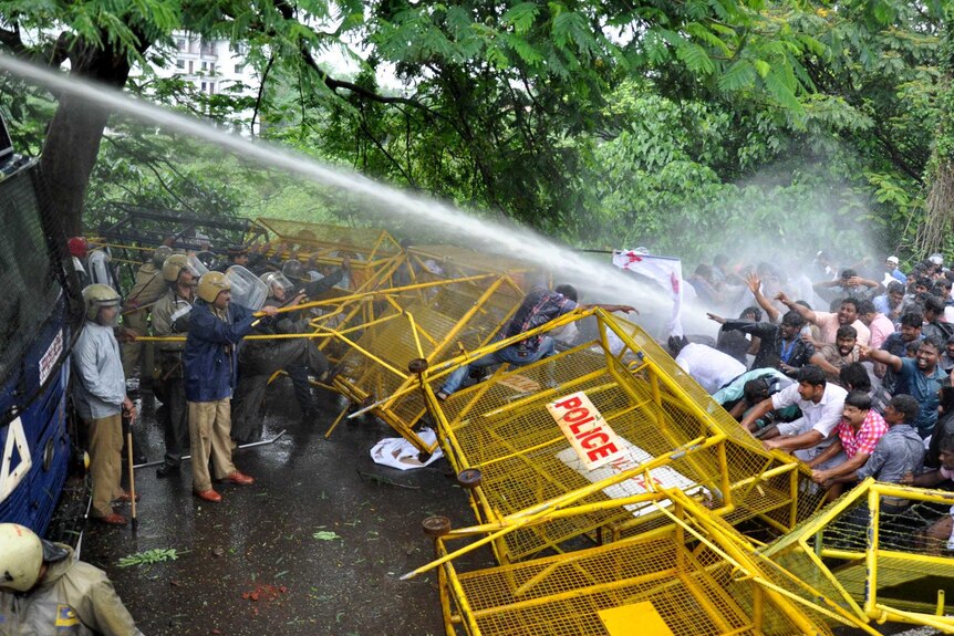 Water is sprayed from a cannon at protesters.