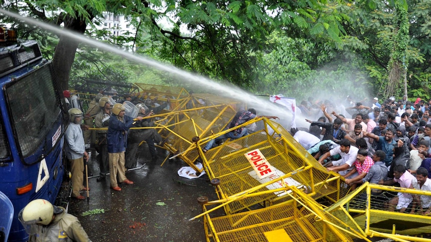 Water is sprayed from a cannon at protesters.