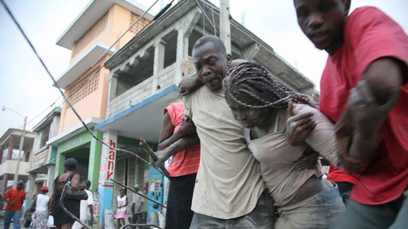 A woman is helped after being trapped inside a damaged building in Port-au-Prince.