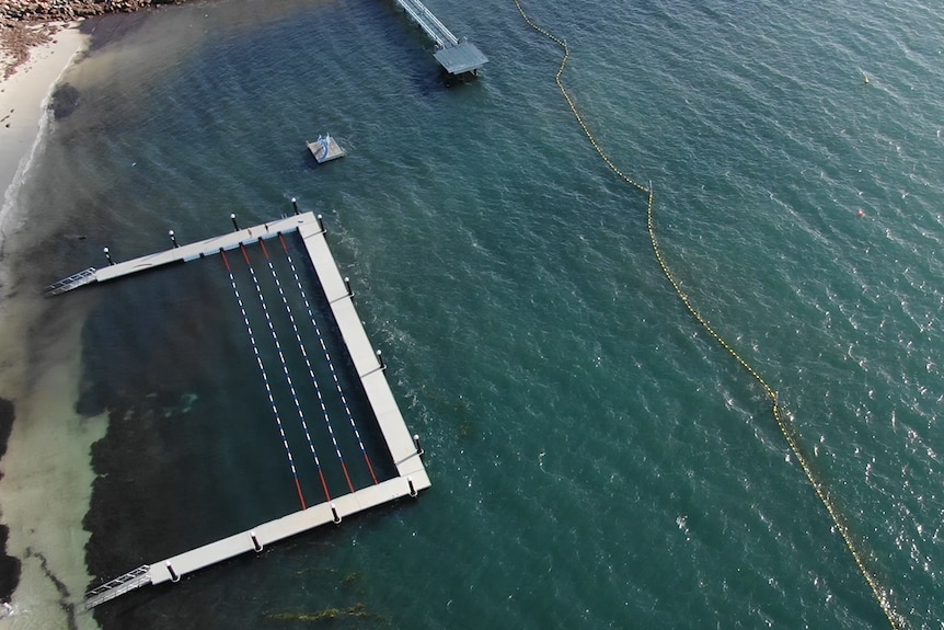 An aerial shot of the lap pontoon and shark barrier. A slide and small jetty are also pictured