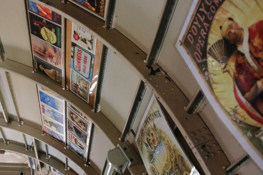 Postcards and pictures on the wall of a plane-turned-campervan