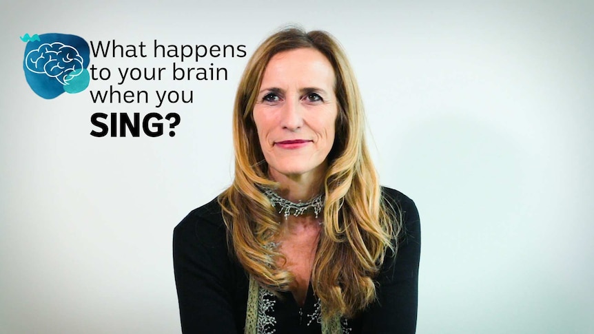 A woman looks towards the camera with the words "What happens to your brain when you sing" on screen.