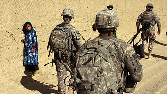 US Army soldiers walk by a girl on January 20, 2010 in Orgune, Afghanistan. (Getty Images: Spencer Platt)