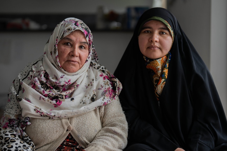Two women wear traditional Hazara headscarves and clothing.