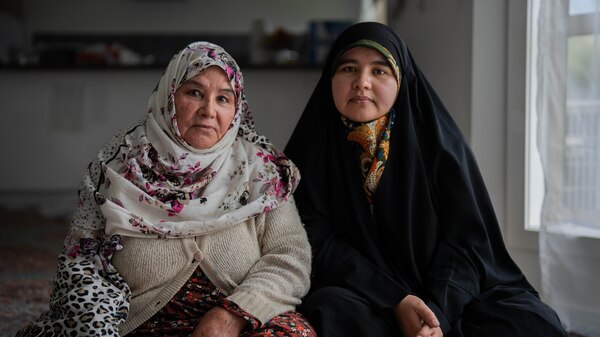 Two women wear traditional Hazara headscarves and clothing.