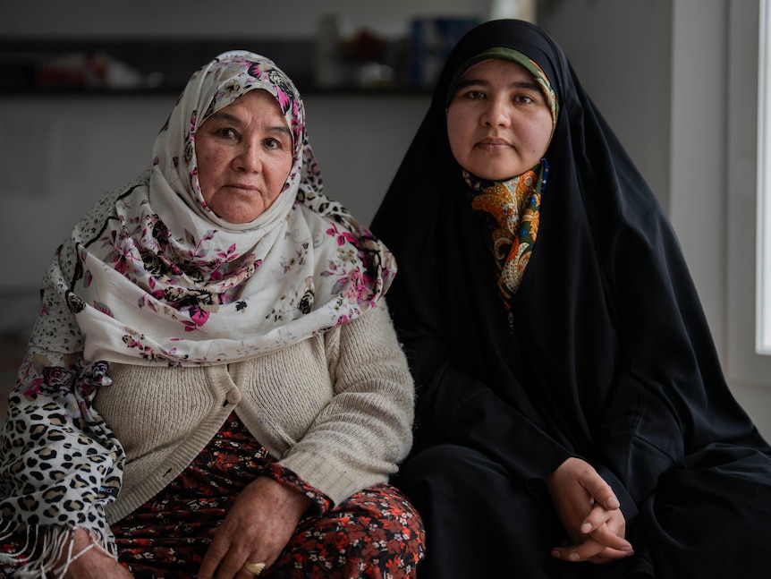 Two women wear traditional Hazara headscarves and clothing.
