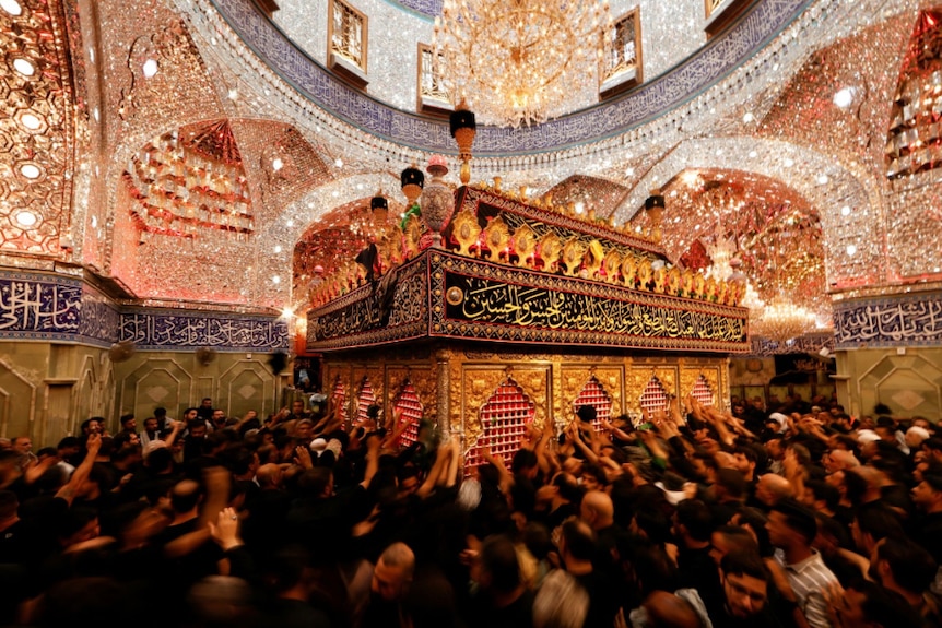 Shi'ite pilgrims reach out to touch the tomb of Imam al-Abbas located inside the al-Abbas Shrine, to commemorate Ashura.