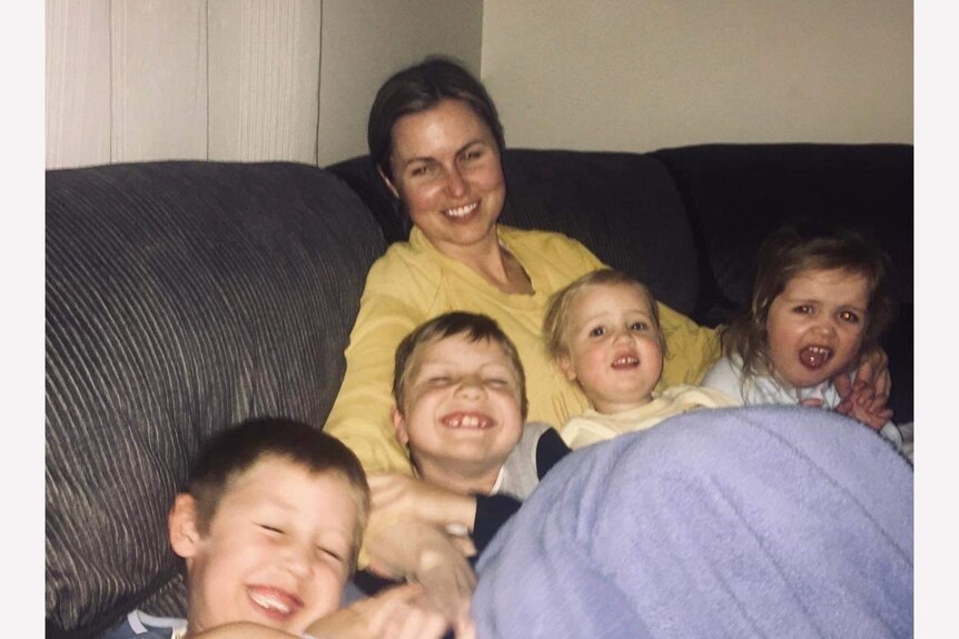 a photo of a woman and four kids on the couch 
