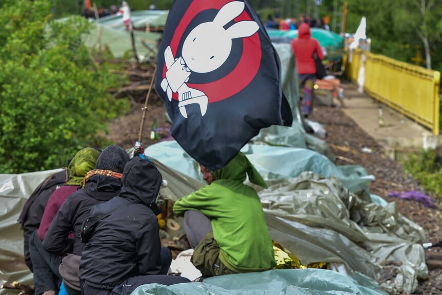 Environmental activists lie on tracks leading to the coal-fired power station.