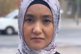 A woman in a headscarf looking straight at the camera. 