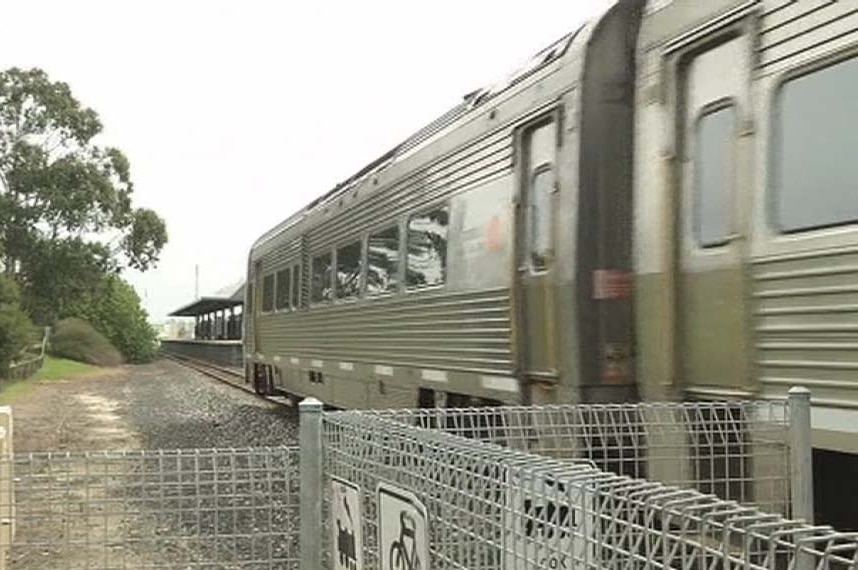 Heading past a station, the Australind is on its way to Bunbury from Perth