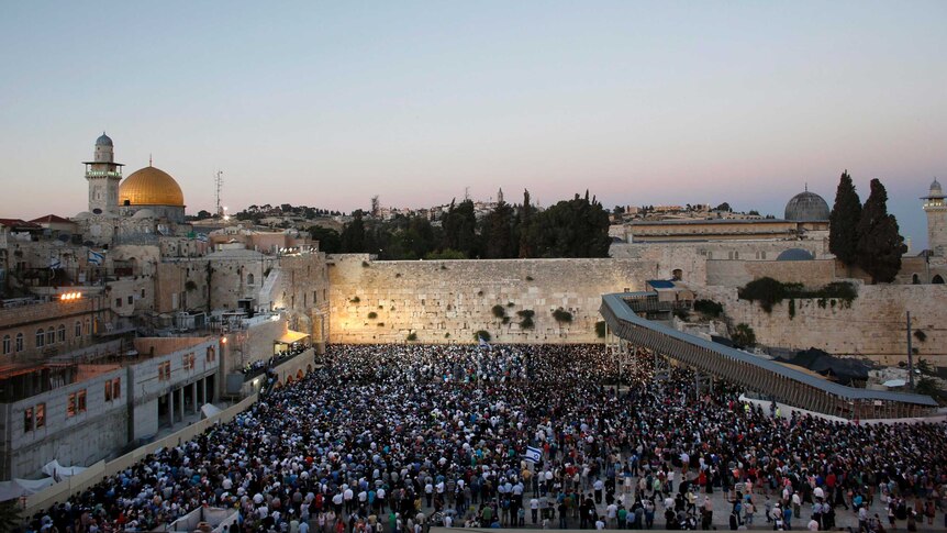 Israelis take part in a mass prayer at the Western Wall for the return of three abducted teenagers.