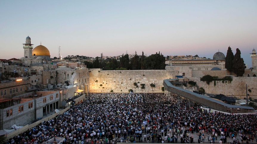 Israelis take part in a mass prayer at the Western Wall for the return of three abducted teenagers.