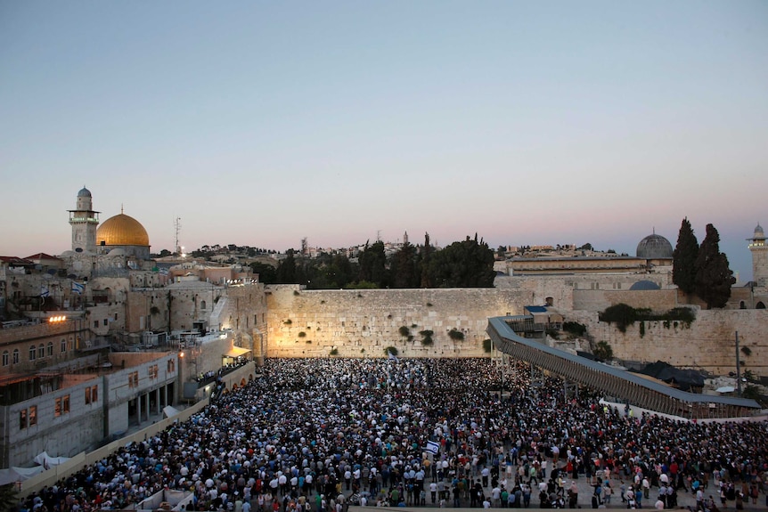 Israelis take part in a mass prayer at the Western Wall for the return of three abducted teenagers.