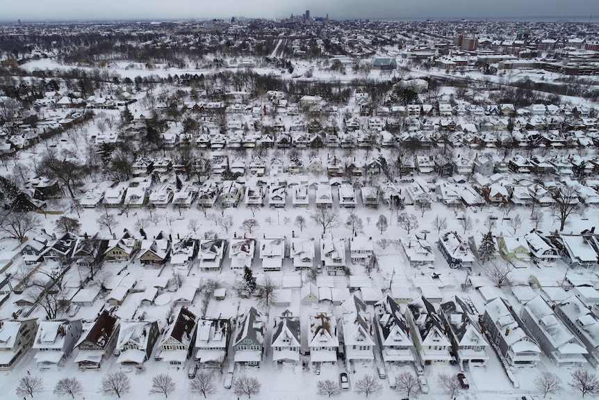Houses covered in snow are pictured form above.