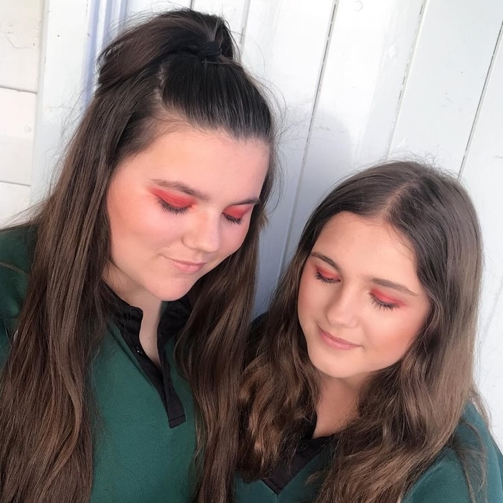 two school students with red eye shadow