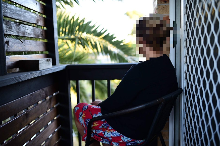 A woman sits with her back to the camera.