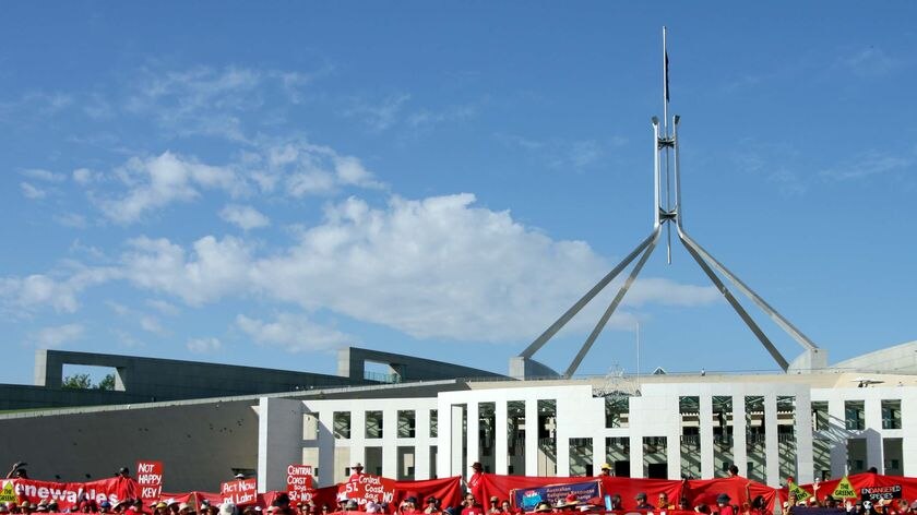 Climate change protesters surround Parliament House in Canberra