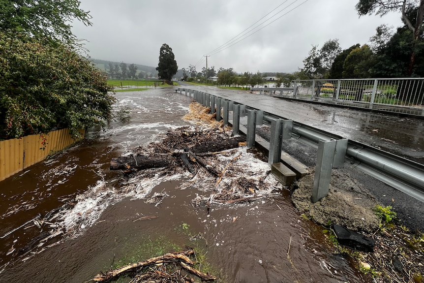 Floodwaters swirl around a bridge
