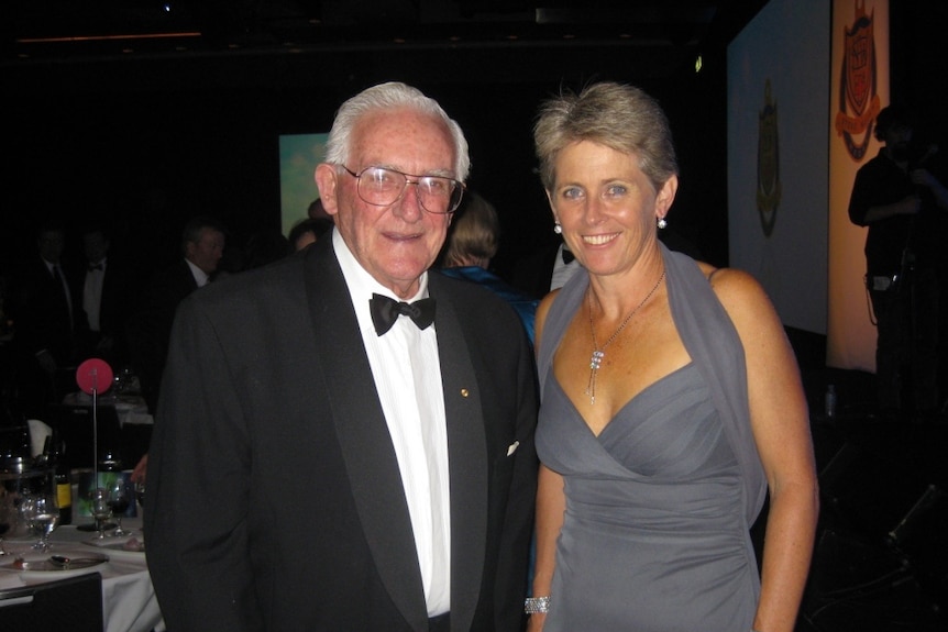 Cricket greats Alan Davidson and Lyn Larsen pose for a photograph at a formal function.