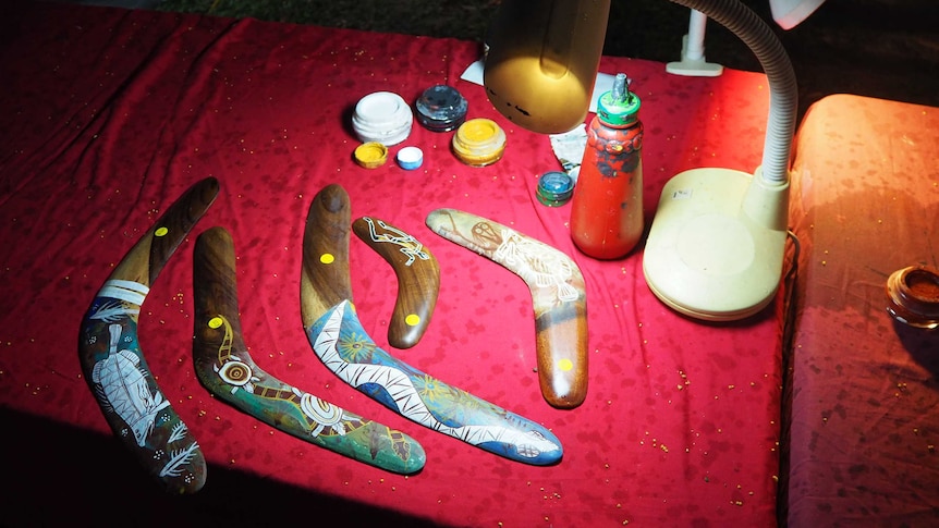A table of boomerangs under a small light.
