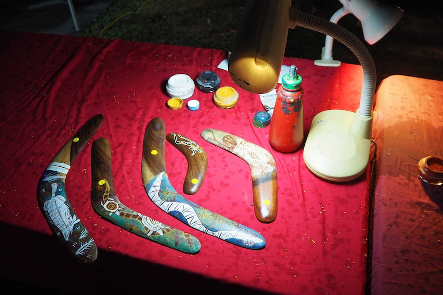 A table of boomerangs under a small light.