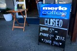 A sign in front of a cafe that says 'closed'