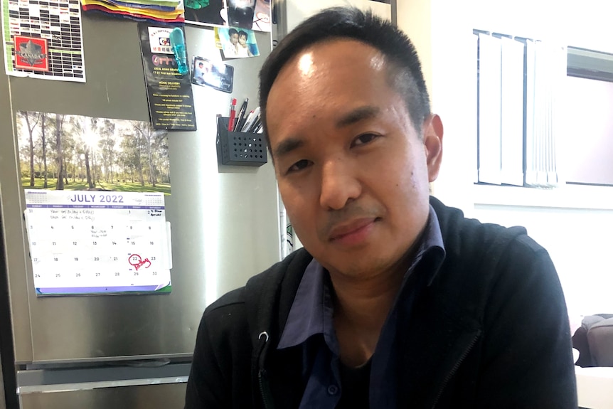 A man sitting at a table with food in front of him holding a fork 