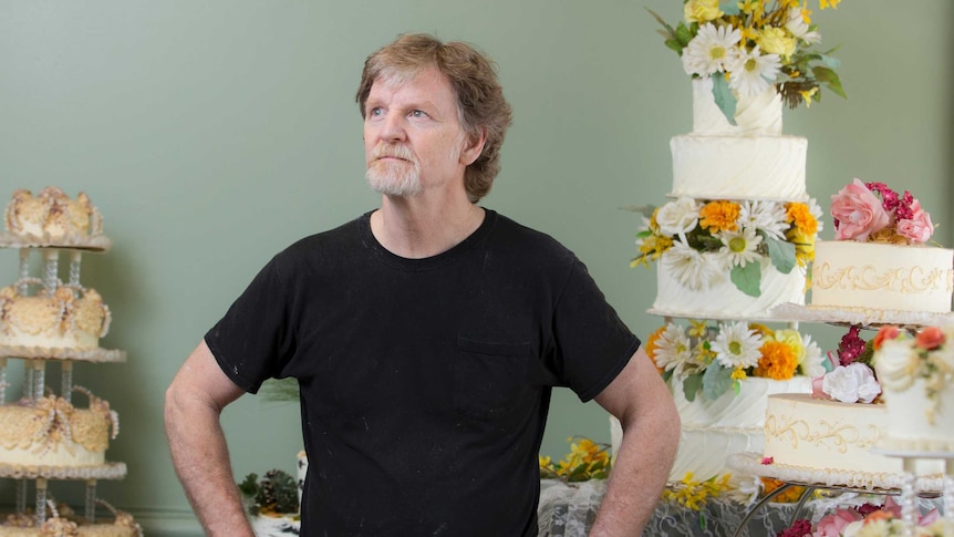 Jack Phillips stands near highly-decorated cakes.