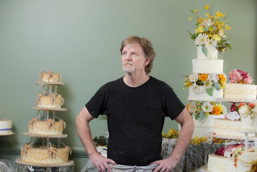 Jack Phillips stands near highly-decorated cakes.