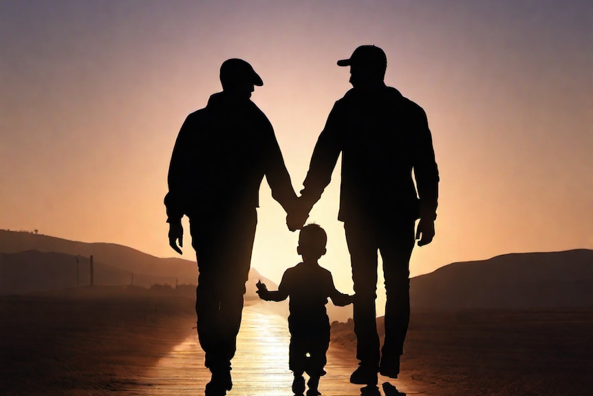 A Same sex family with a child walk at sunset in a silhouette image.