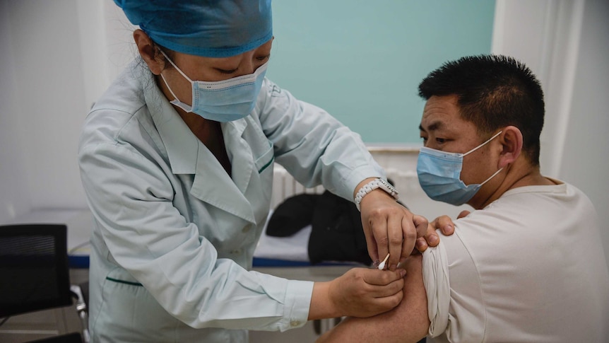 A man was receiving COVID-19 vaccine in a medical room.