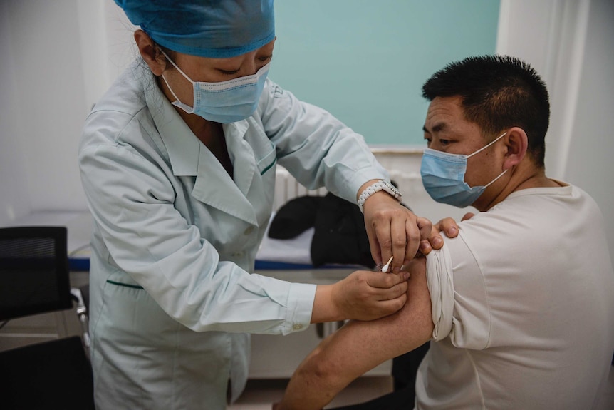 A man was receiving COVID-19 vaccine in a medical room.